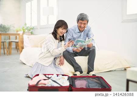 旅行の準備をする笑顔のシニア夫婦 旅行の準備をする笑顔のシニア夫婦 141426388