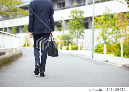屋外を歩く20代のビジネスマンの後ろ姿 屋外を歩く20代のビジネスマンの後ろ姿 141426412