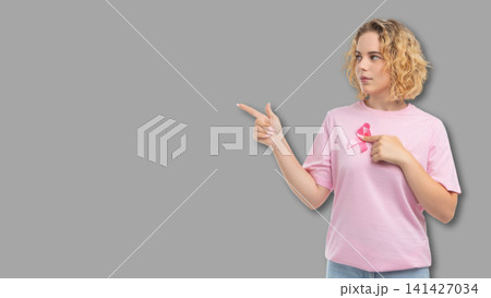 Person gestures with pink cancer awareness ribbon 141427034