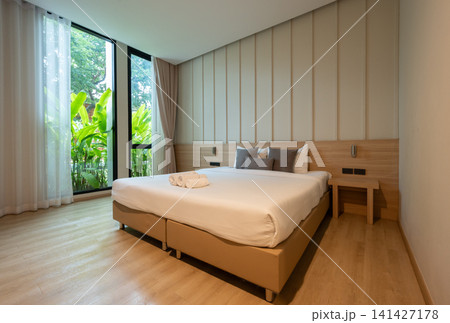 Scenery view in comfortable bed in hotel bedroom. Conceptual shot of a place for someone to stay, live, or work temporary. 141427178