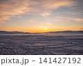 Car driving on frozen lake Baikal in winter season at sunset. The surface of lake covered by snow.  141427192
