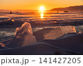 Cracked ice on frozen lake Baikal at sunset seen from Listvyanka town, Russia. 141427205