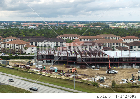 Development of commercial housing in USA. Construction works on monolithic frame. Large building site with scattered workers and equipment. Real estate market 141427695
