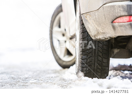 Close-up of car wheel in winter tire on snowy road Close-up of car wheel in winter tire on snowy road 141427781