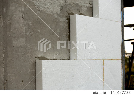 Close-up detail of plastered house wall with rigid styrofoam insulation. Modern technology, construction, renovation, energy saving, alternative for mineral wool, warm comfortable house concept. 141427788