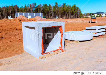 Workers are preparing construction site with concrete blocks machinery under road works 141428475