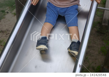 公園の滑り台をすべる半ズボンの子供の足元 公園の滑り台をすべる半ズボンの子供の足元 141428548