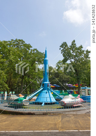 レトロな遊園地のロケット型タワーと飛行機のりもの、ノスタルジックなアミューズメントの風景 レトロな遊園地のロケット型タワーと飛行機のりもの、ノスタルジックなアミューズメントの風景 141428632