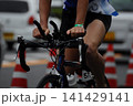 トライアスロンのバイク競技で激走する選手の手元とロードバイク 141429141