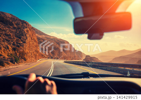 Driving a car on the mountain road in the desert. View of sandstone mountains through the windscreen. The road from Arad to the Dead Sea. Israel 141429915
