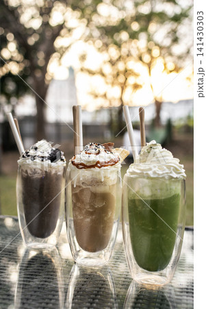 Chocolate and Coffee ice cream sundae milkshake drinks on outdoor cafe table Chocolate and Coffee ice cream sundae milkshake drinks on outdoor cafe table 141430303