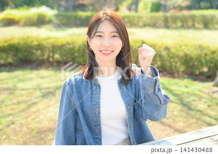 公園でガッツポーズをする日本人女性 公園でガッツポーズをする日本人女性 141430488
