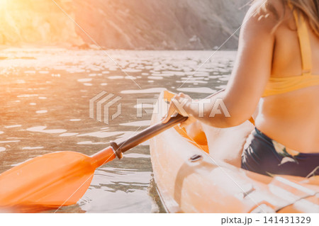 Kayaking, Woman, River: A woman kayaks down a river on a sunny day. Kayaking, Woman, River: A woman kayaks down a river on a sunny day. 141431329