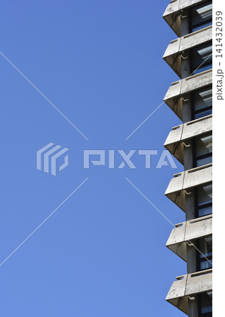Brutalist concrete apartment building balconies against blue sky Brutalist concrete apartment building balconies against blue sky 141432039