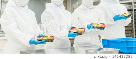 厨房でお弁当の盛り付けをする男女（食品工場,食品加工,食品衛生） 141432283