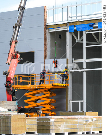 Installing Insulated Sandwich Wall Panels with Scissor Lift at Modern Industrial Construction Site Installing Insulated Sandwich Wall Panels with Scissor Lift at Modern Industrial Construction Site 141432498
