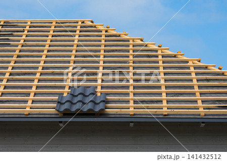 Roof battens and underlayment prepared for roof tile installation on modern timber frame house 141432512