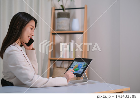 タブレットを見ながら投資について相談する女性 タブレットを見ながら投資について相談する女性 141432589