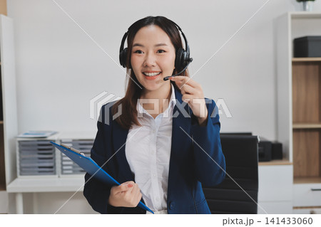Smiling Asian Woman Telemarketing Agent with Headset Working at 141433060