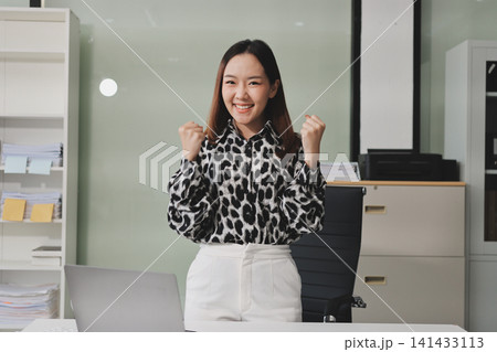 Confident asian business woman standing in modern office Confident asian business woman standing in modern office 141433113
