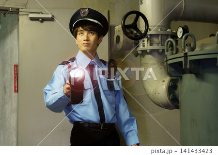 ビルの地下を懐中電灯を持って警備する男性警備員 撮影協力:学校法人電波学園 東京電子専門学校 ビルの地下を懐中電灯を持って警備する男性警備員 撮影協力:学校法人電波学園 東京電子専門学校 141433423