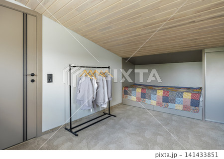 Bedroom Interior with Single Bed, Clothing Rack, and Wardrobe 141433851
