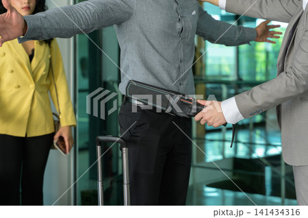 Security man check passenger at entrance in airport terminal Security man check passenger at entrance in airport terminal 141434316