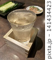 升に入れられた冷たい日本酒のグラス 141434423