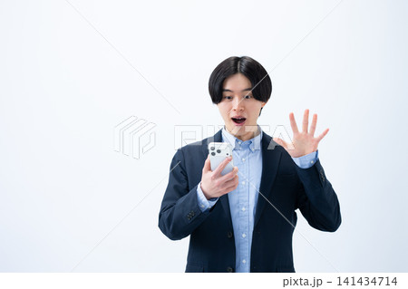 スマホを持って驚く男性 141434714