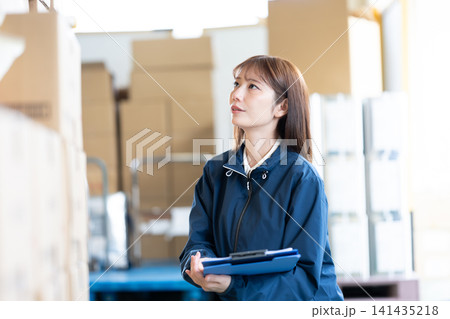 倉庫で作業する女性スタッフ 倉庫で作業する女性スタッフ 141435218