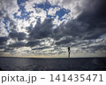 低空に厚い雲が出現し太陽に上から照らされる太平洋 141435471