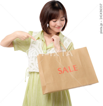Asian woman holding sale paper bag transparent background showing excited expression with joyful smile while pointing promotion shopping purchase retail consumer offer. PNG file format Asian woman holding sale paper bag transparent background showing excited expression with joyful smile while pointing promotion shopping purchase retail consumer offer. PNG file format 141436337