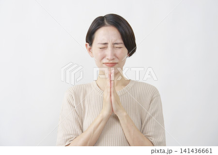 白背景で目を閉じて祈る40代女性 141436661