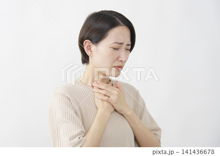 白背景で喉を押さえ息苦しそうな40代女性 白背景で喉を押さえ息苦しそうな40代女性 141436678