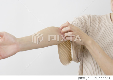 白背景で腕を掻く40代女性の手元 白背景で腕を掻く40代女性の手元 141436684