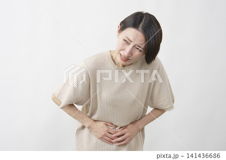 白背景で激しい腹痛に苦しむ40代女性 白背景で激しい腹痛に苦しむ40代女性 141436686