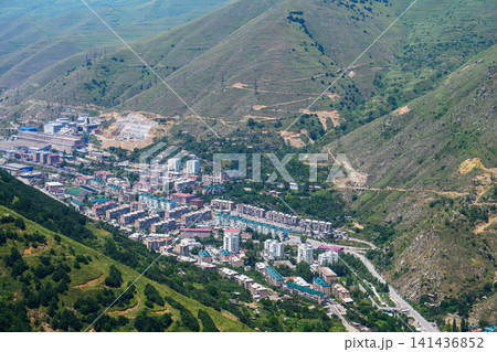 Aerial view of small town surrounded by hills and forests Aerial view of small town surrounded by hills and forests 141436852