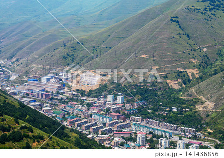 High-angle view of Kajaran town in mountain valley with green hillsides High-angle view of Kajaran town in mountain valley with green hillsides 141436856