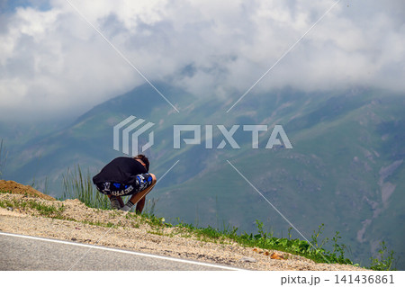 Mountain hiker pauses on road for photo 141436861