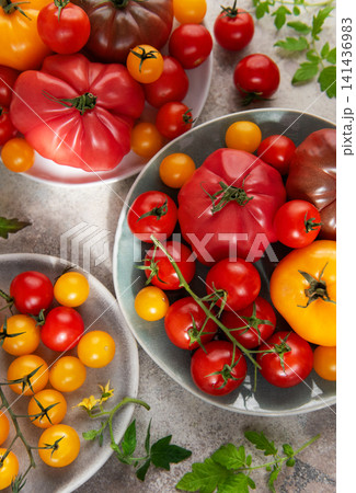 Fresh heirloom and cherry tomatoes on plates 141436983