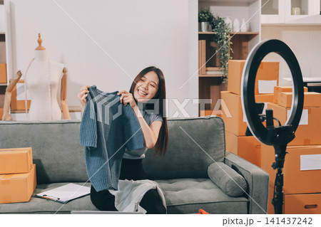 Woman recording live stream preparing packages for online selling Woman recording live stream preparing packages for online selling 141437242