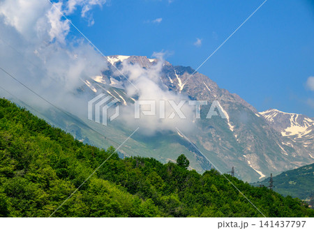 Clouds swirl around majestic mountain summits Clouds swirl around majestic mountain summits 141437797