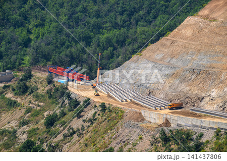 Building infrastructure with pipes and machinery on a steep Building infrastructure with pipes and machinery on a steep 141437806