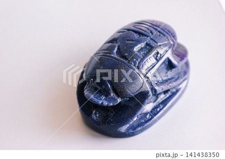 Carved blue lapis lazuli scarab beetle amulet isolated on white background. Carved blue lapis lazuli scarab beetle amulet isolated on white background. 141438350