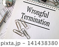 Wrongful Termination text on notebook with pen and paperclips on white background, labor law and employment concept 141438380