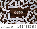 ADHD word spelled with small letter tiles surrounded by scattered white letters on wooden background, mental health concept 141438393