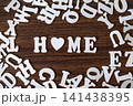 HOME word with heart symbol spelled with letter tiles on scattered letters wooden background, real estate and family concept 141438395