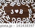 JOB word with heart symbol spelled with letter tiles on scattered letters wooden background, employment and career concept 141438397