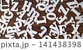 Scattered white wooden letter tiles on dark brown wooden background, education and typography abstract concept 141438398