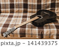 Black acoustic guitar resting on a couch at home 141439375